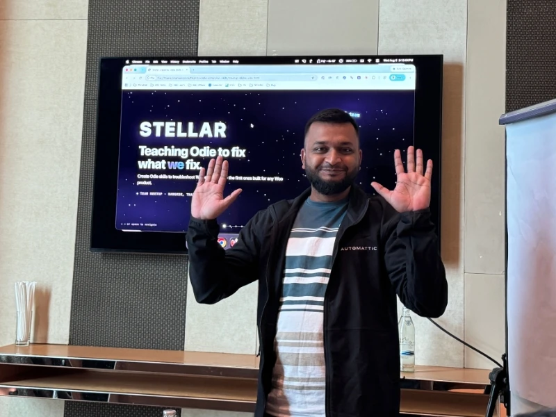 Shameem waving in front of a presentation screen